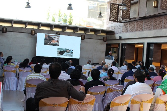 Dr. Saud Ahmed presenting at a medical conference to a full audience